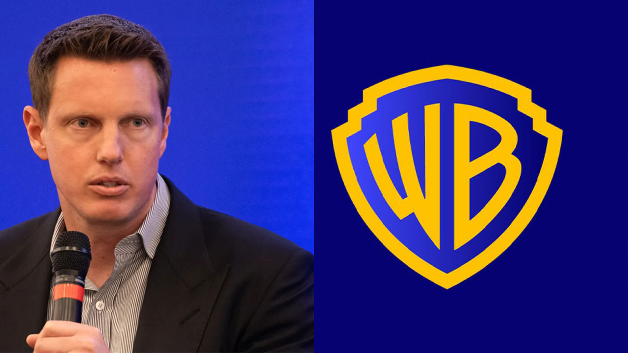 David Ellison ao lado do logotipo da Warner Bros.